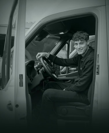 Comfortabele man in de bestuurdersstoel van een vrachtwagen, klaar voor werk of levering.