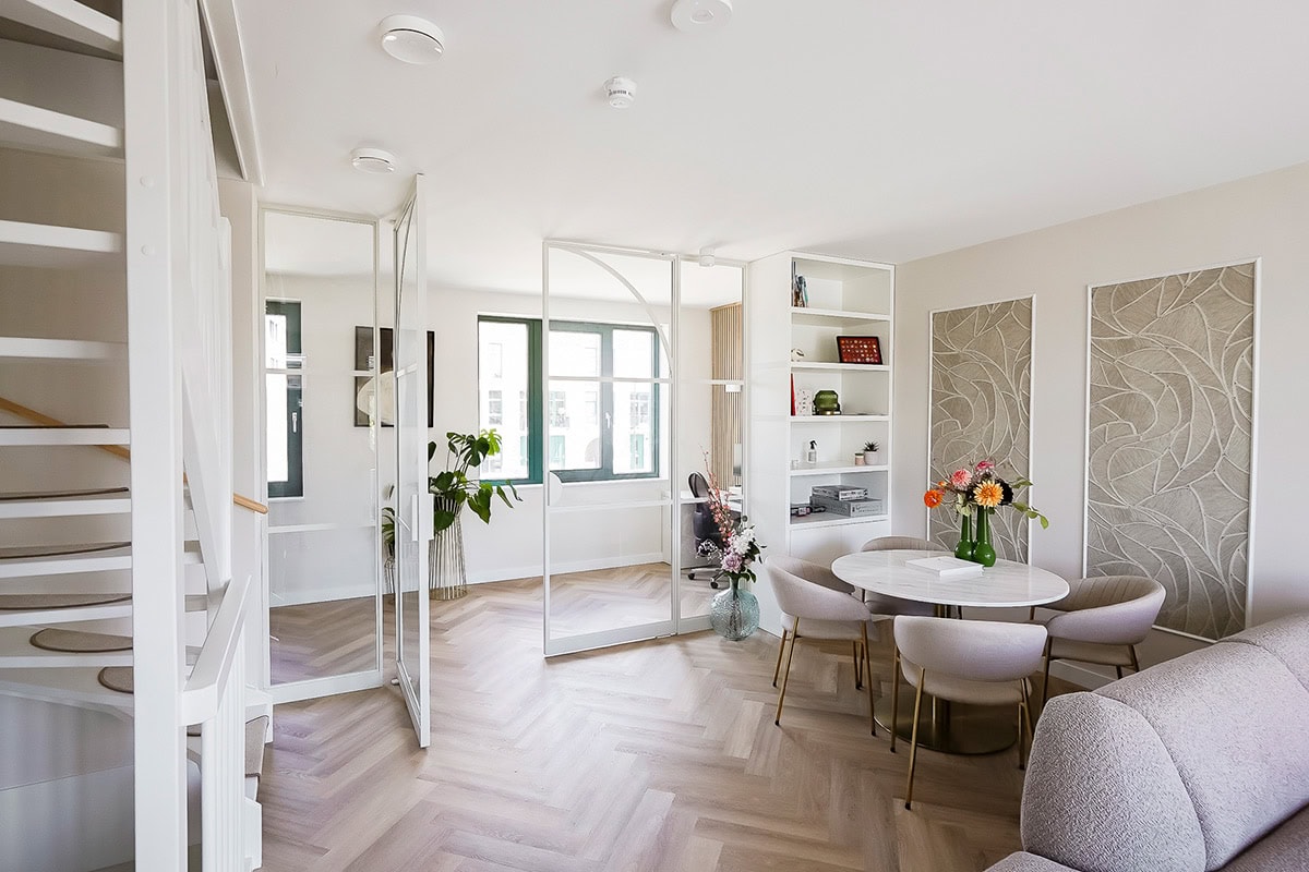 Modern stalen schuifdeur in een lichte woonkamer, op maat gemaakt voor optimale ruimte-indeling.