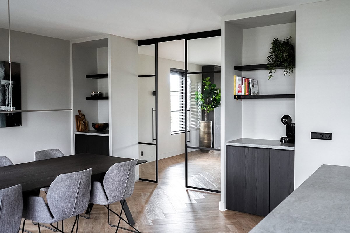 Hoogwaardige stalen scheidingswand met zwarte metalen profiel in een modern interieur.