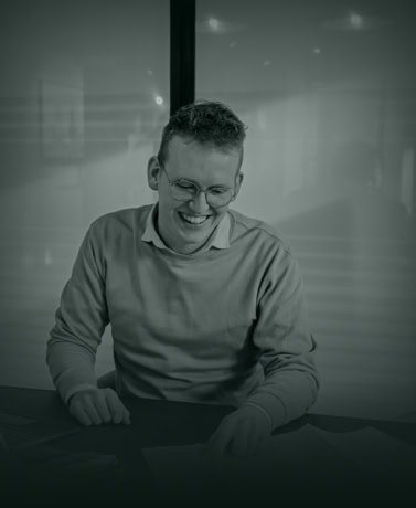 Elegante man die documenten bekijkt in een modern kantoor, vertegenwoordigt professionele service en maatwerk bij Aluwdoors.