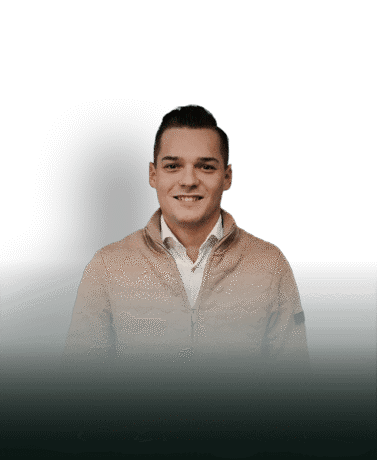 Strakke man met lichte jas en witte blouse, voor een witte achtergrond met schaduw.