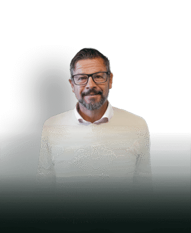 Elegante man in een wit trui met glazen, lachend en vriendelijk, op een witte achtergrond met schaduw, geschikt voor zakelijke of interieur gerelateerde content.