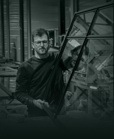 Hoogwaardige stalen glazen deur op maat geïnspecteerd door vakman in de productiehal.