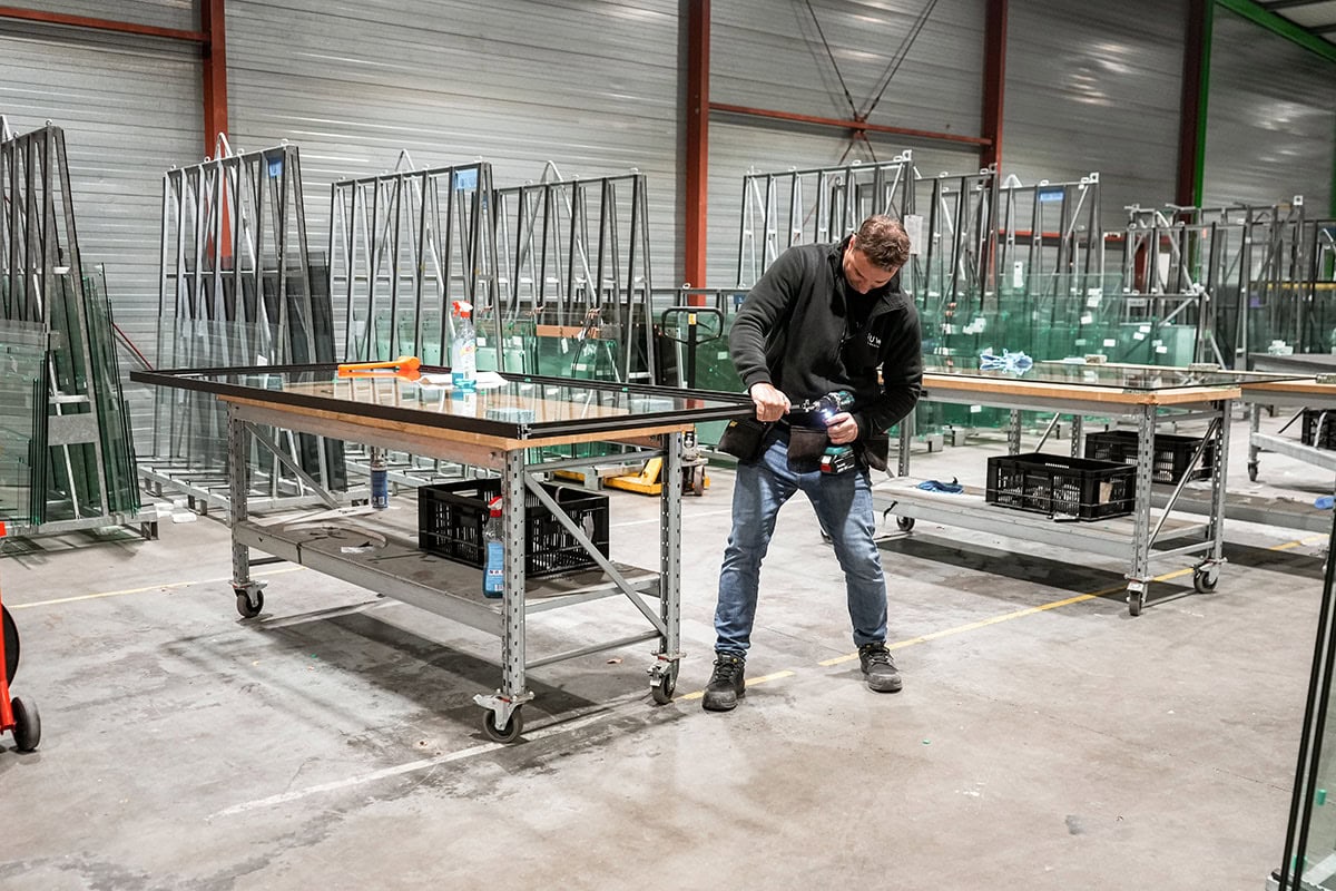Gejacige stalen deuren en wanden op maat worden in een industriële werkplaats vervaardigd en geassembleerd door een vakman.