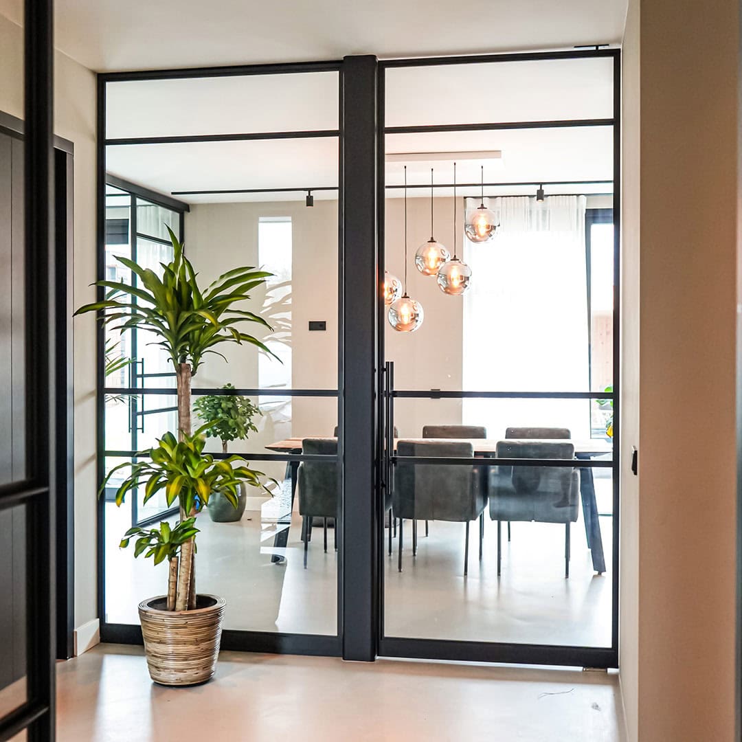 Elegant steel dividing door with glass panels and black finish for a modern interior layout.