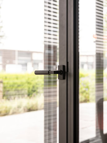 A close-up of a sleek, black steel door with handle, perfectly tailored for a stylish and durable interior finish.