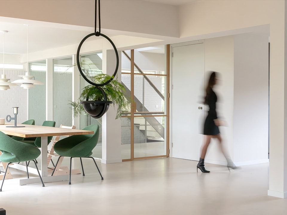 Modern steel door in a contemporary living space, with a glass wall and wooden details, matching high-quality custom-made steel doors and walls.