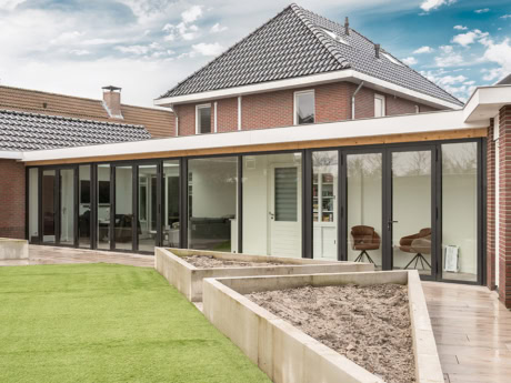 Aluminium external facade in Harderwijk with large glass panels, perfect for a sleek and modern look to the home. Bespoke steel doors and walls for a stylish outdoor space.